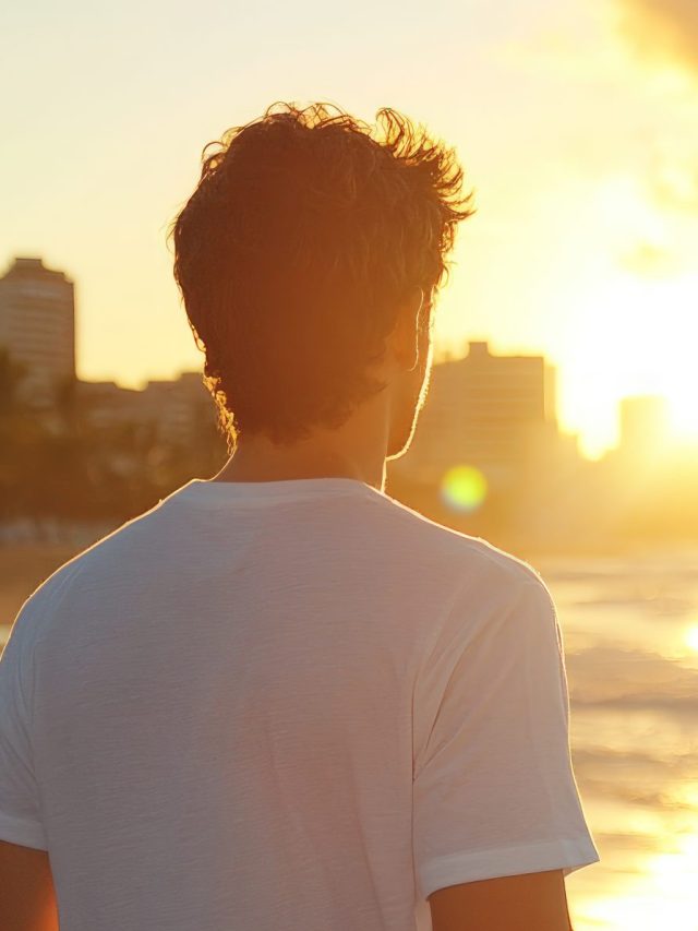 Person watch sunset over city beach horizon